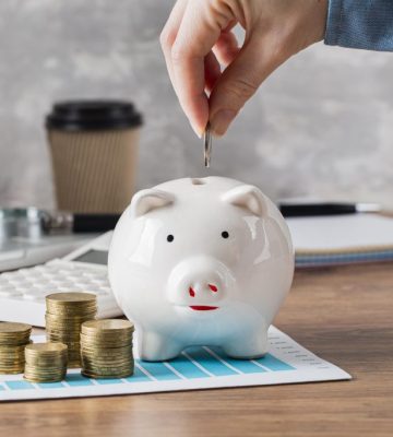 hand-putting-coin-piggy-bank-growth-chart
